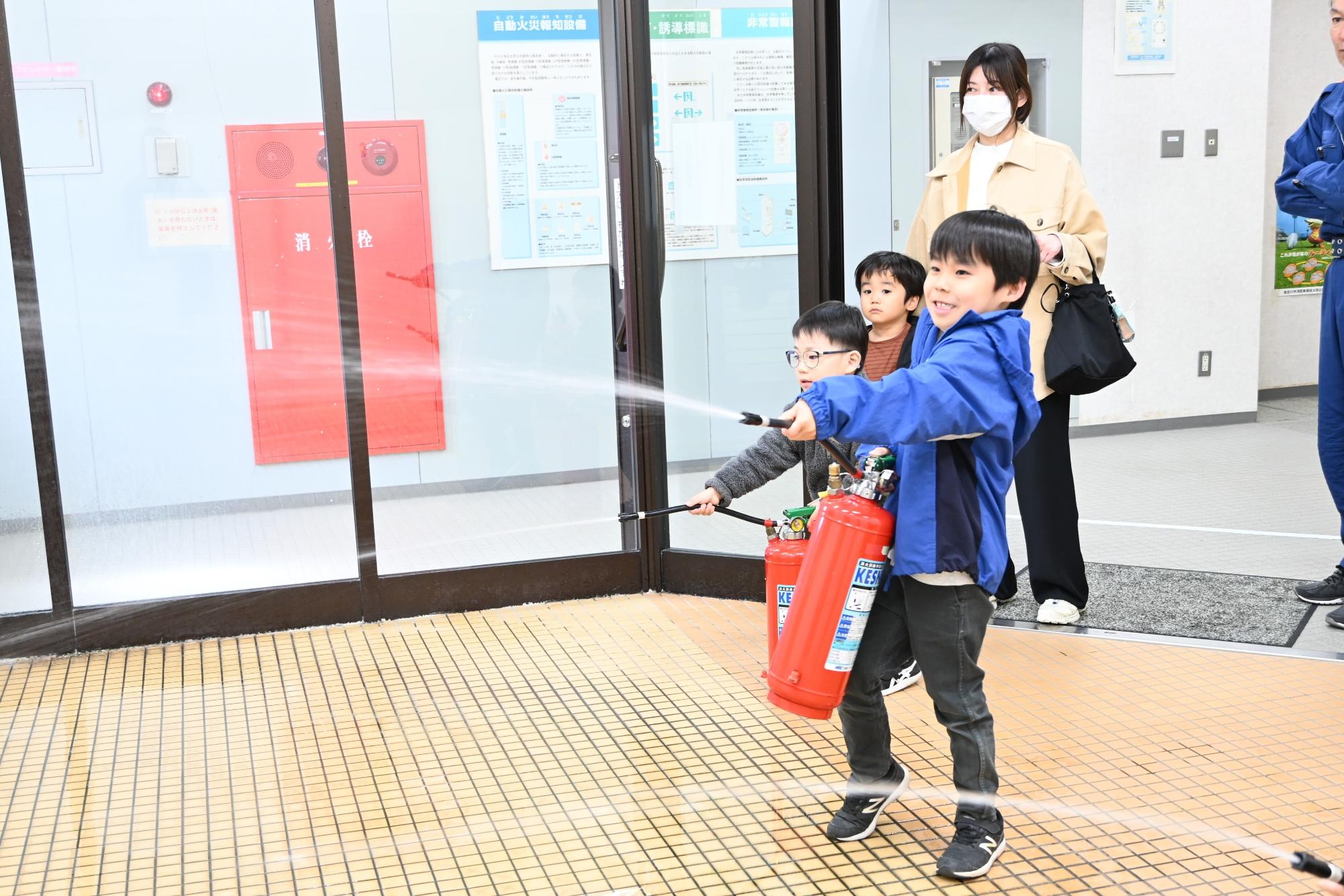 消火器体験をするこどもたち