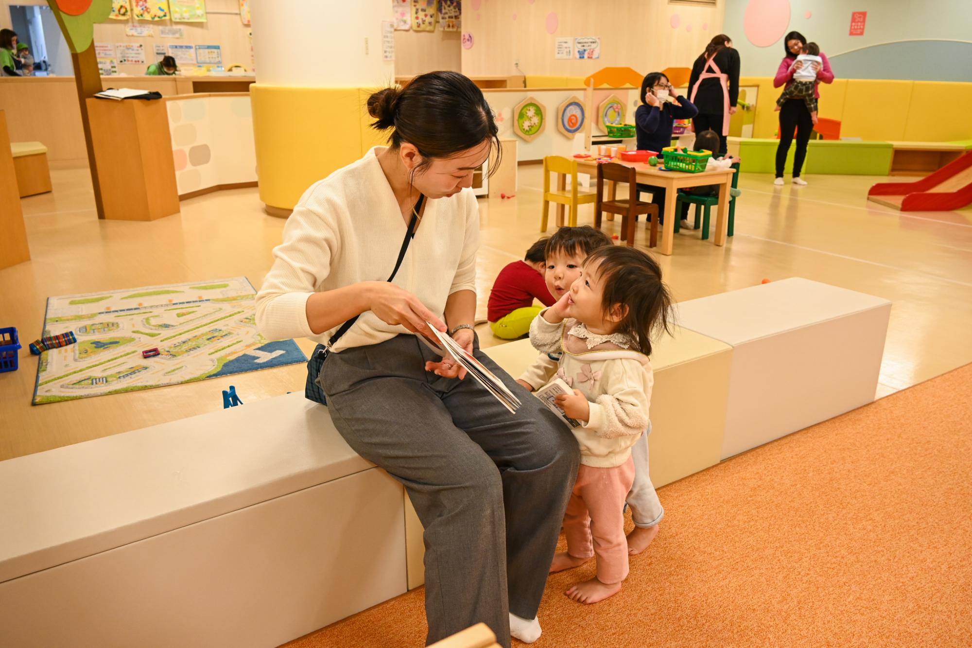 子育てプラザで絵本を読む親子