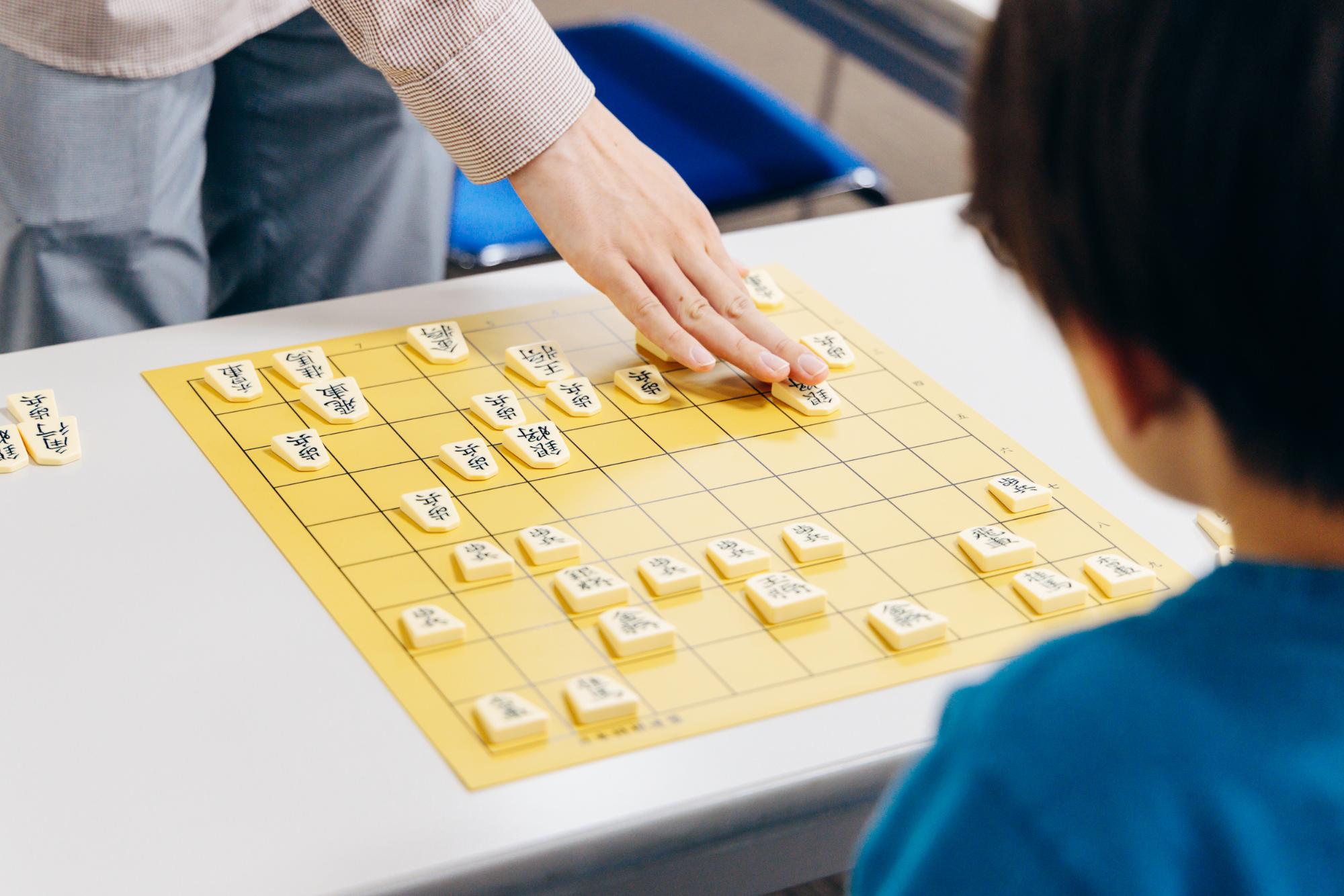 子どもに将棋を教える慶田さん