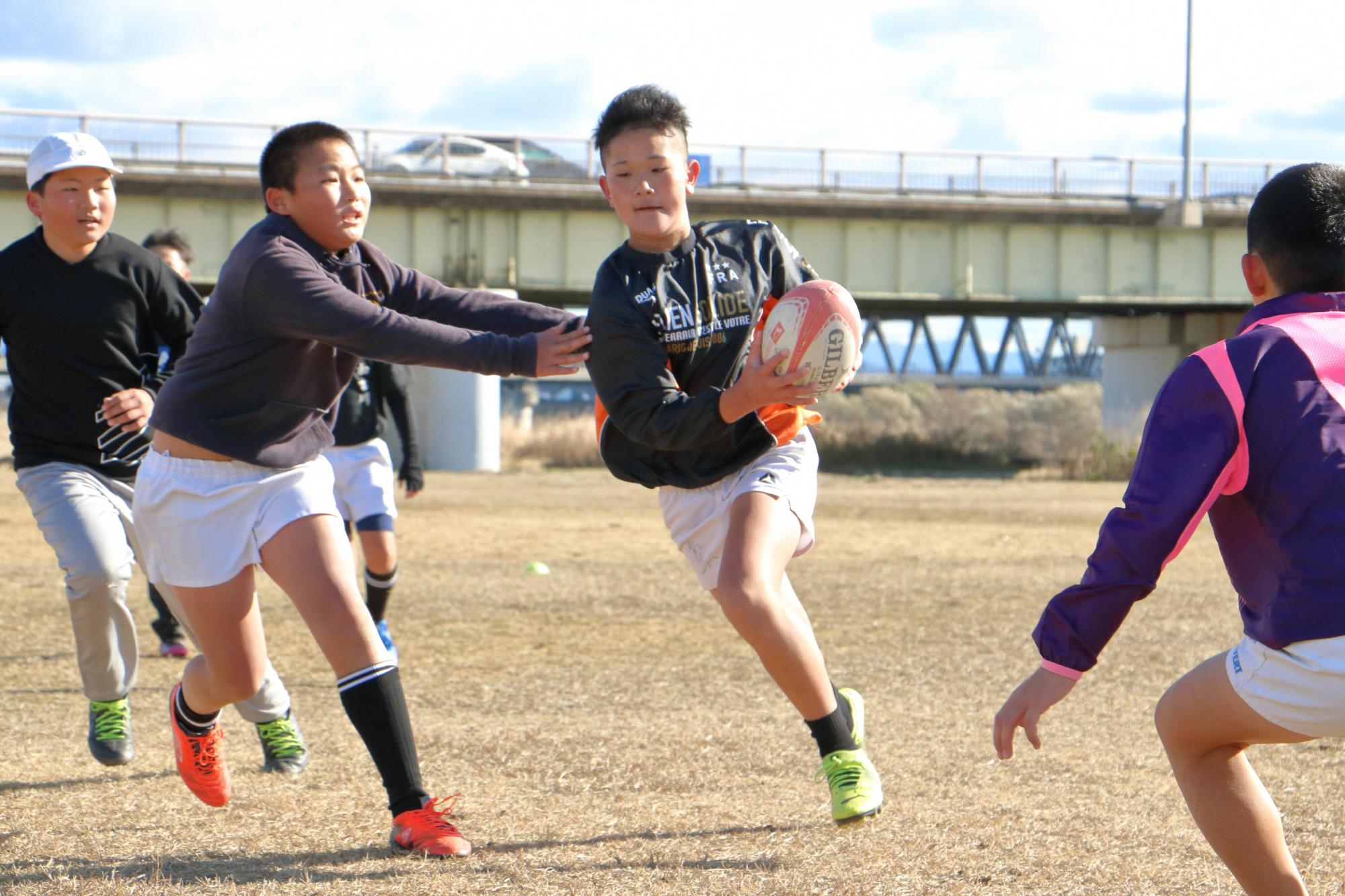 加古川河川敷でラグビーの練習をする子どもたち