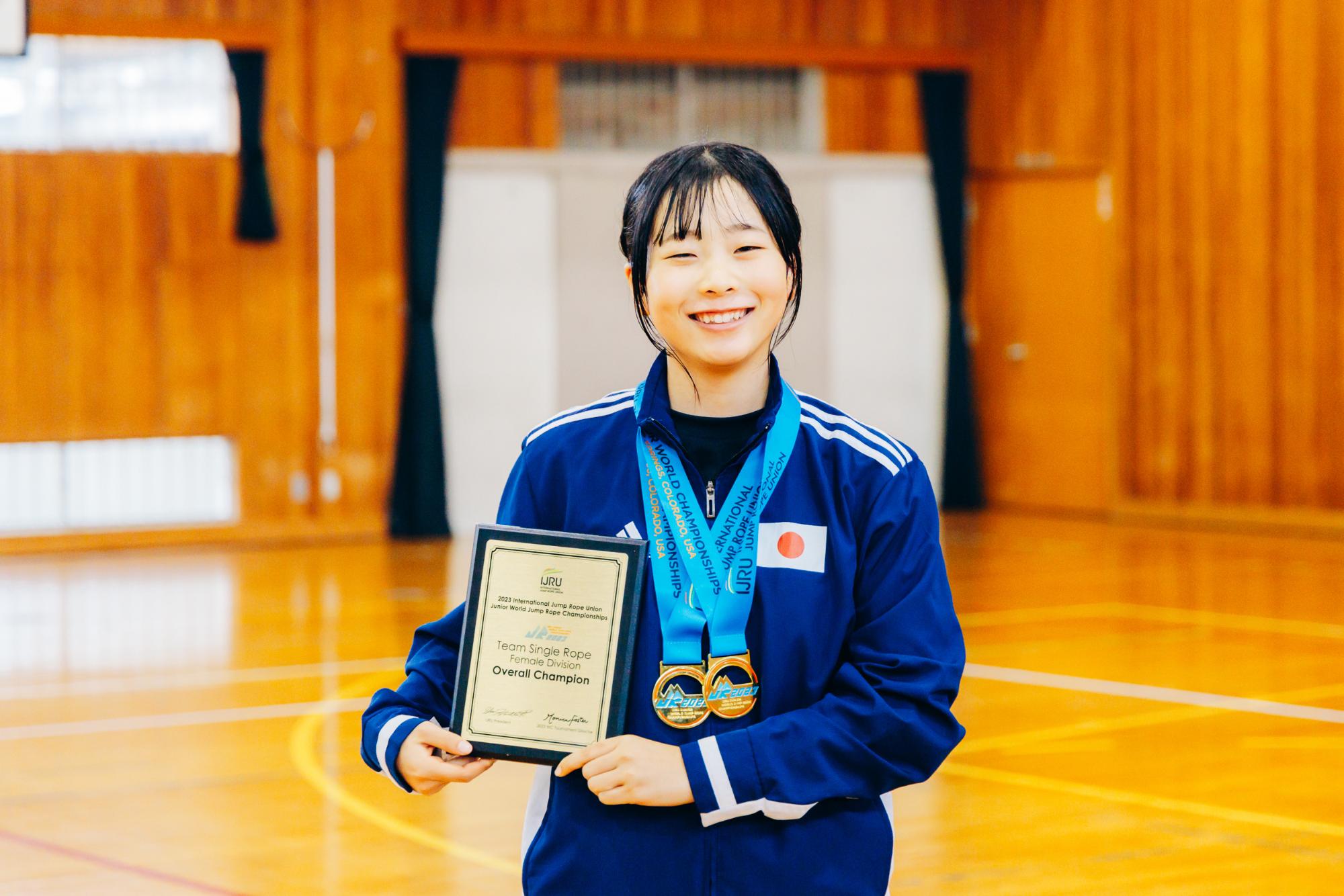 世界大会のメダルと賞状を持つ高田さん