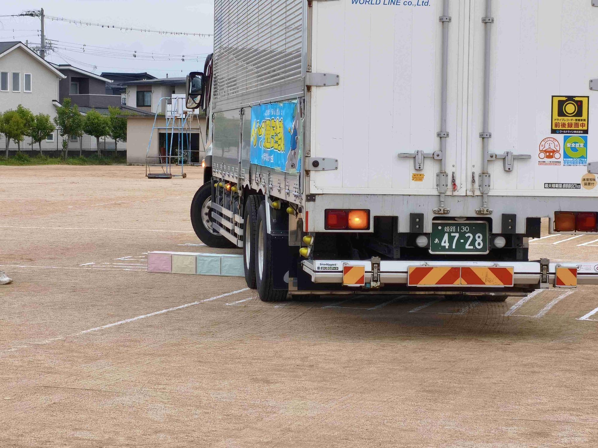 巻き込み事故実験で箱を巻き込む寸前のトラック