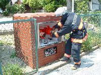 屋外に設置された防火水槽の点検をする職員の写真