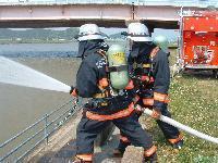 放水訓練をしている消防隊員の写真。奥に消防車両が確認できる