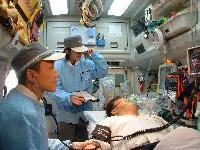 救急車の中で傷病者の状態をモニターで確認する隊員の写真