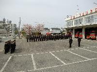 訓練礼式の遠景の写真。職員約40名が消防署の前に整列している