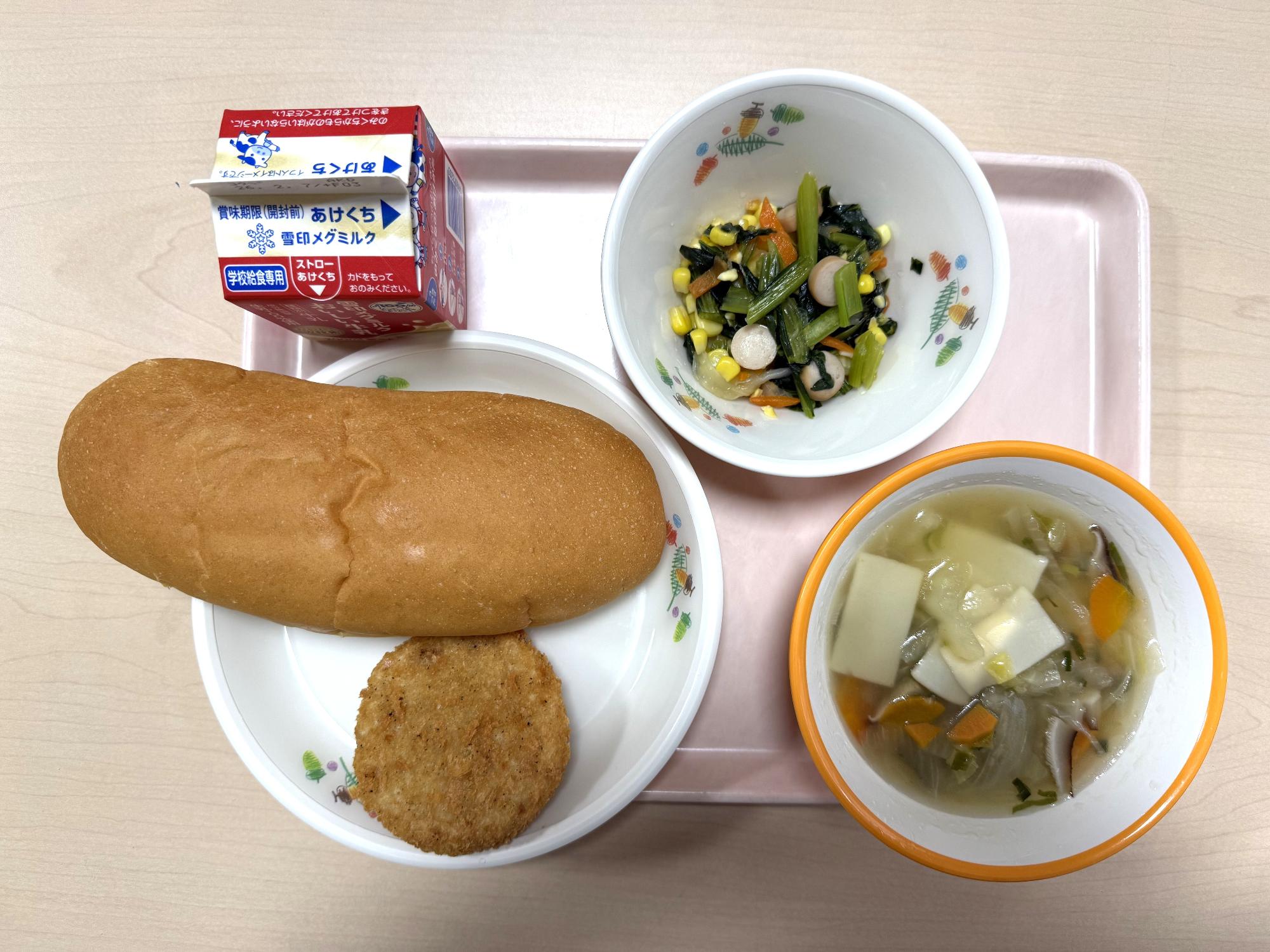 給食を上から撮影した写真。パン、牛乳、淡路玉ねぎコロッケ、小松菜ソテー、ワンタンスープ