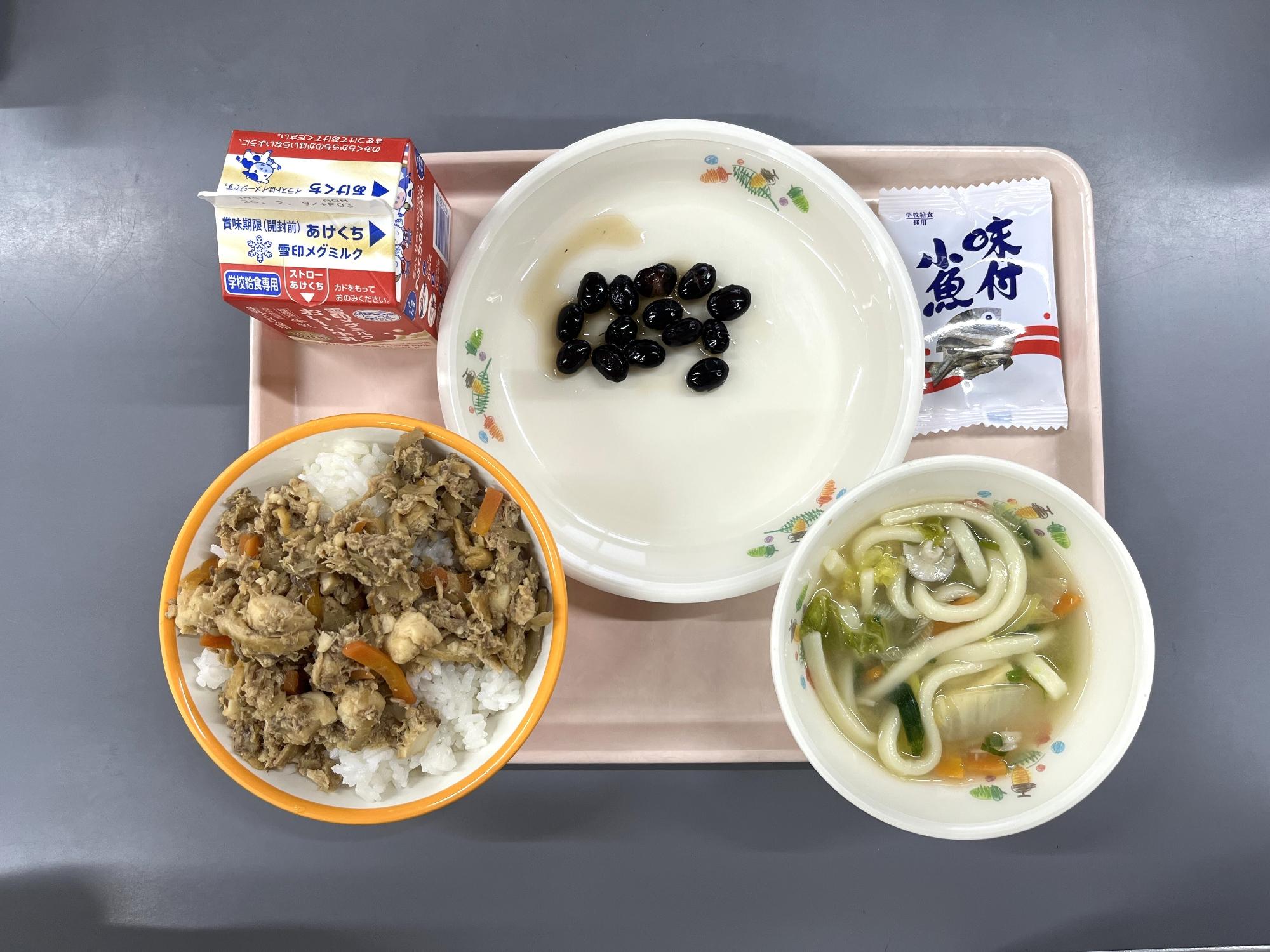 給食を上から撮影した写真。とふめし、牛乳、黒豆、ちゃんこ、お魚スナック