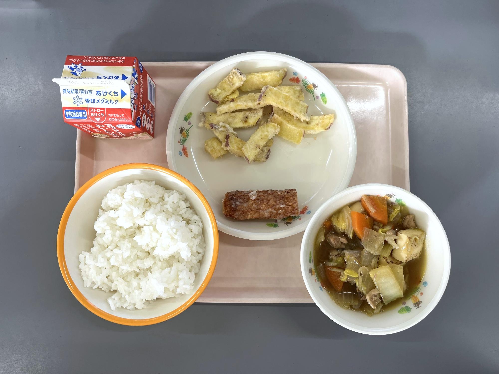 給食を上から撮影した写真。ご飯、牛乳、じゃぶ煮、ちくわの天ぷら、さつまいものごま揚げ