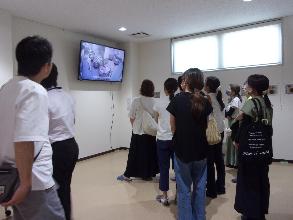 テレビモニターで給食の調理の様子を見ている保護者