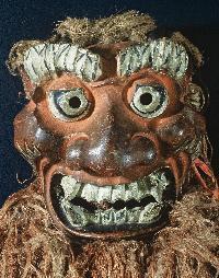 大きな歯と太い眉の赤鬼の面の写真