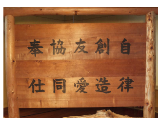 少年自然の家の5つの目標「自律」「創造」「友愛」「協同」「奉仕」が書かれた木製の看板の写真