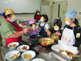 わいわいクラブで調理に挑戦している女子小学生の写真