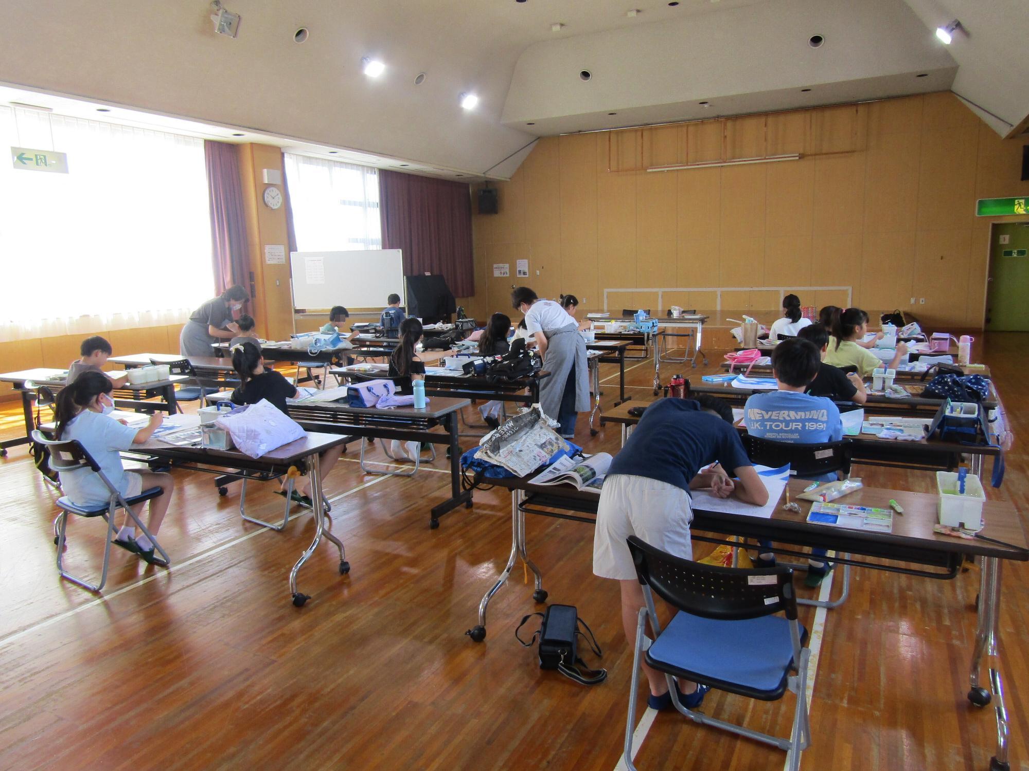 一人1つ長机について、ポスターを描いている様子