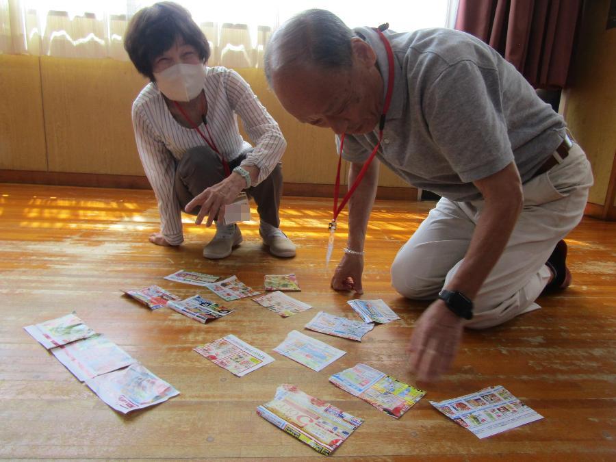1年生がレクリエーションで、チラシパズルをペアで楽しむようす