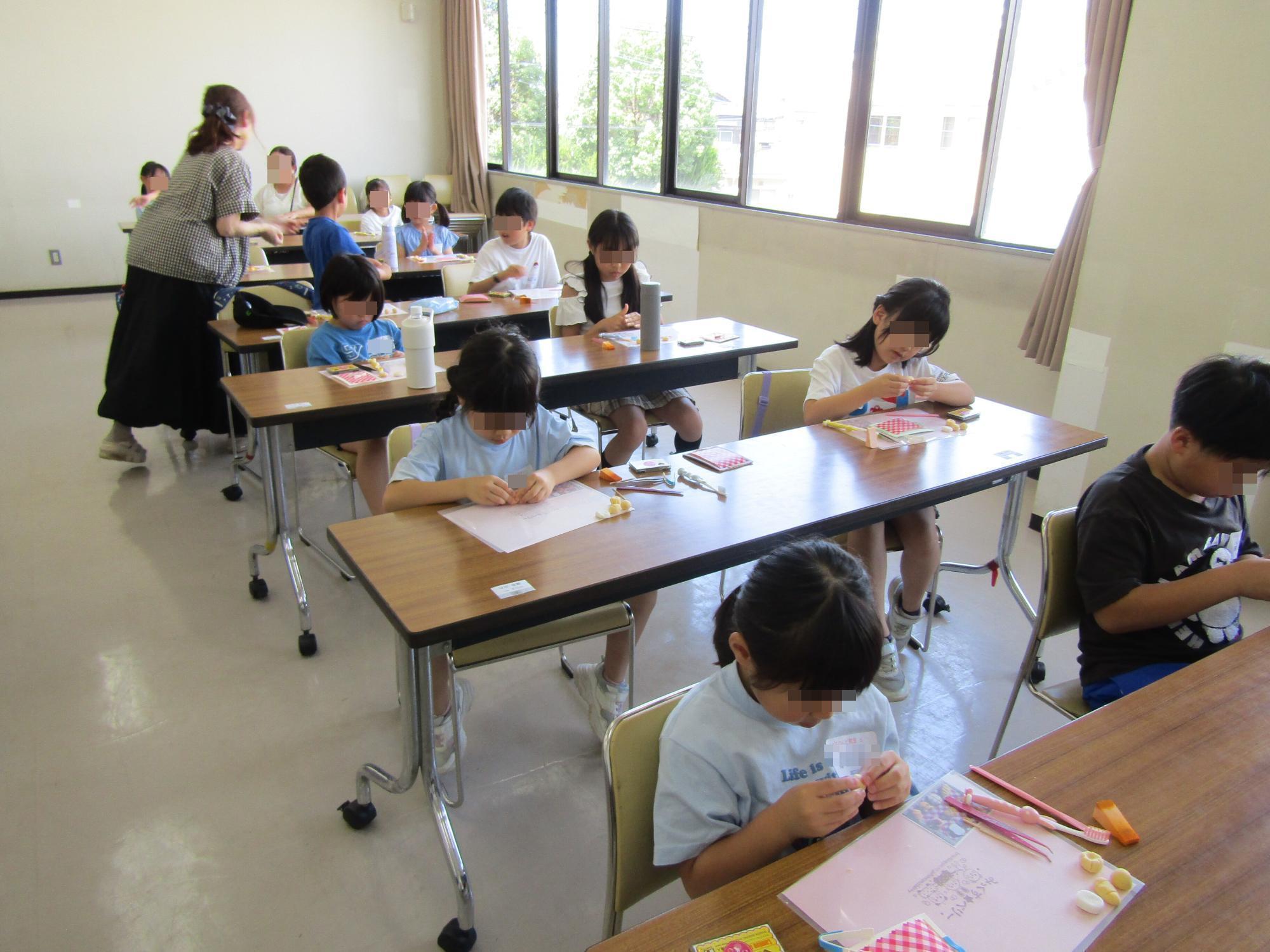 小学生たちが講義室でねんど工作の講座を受けているようす