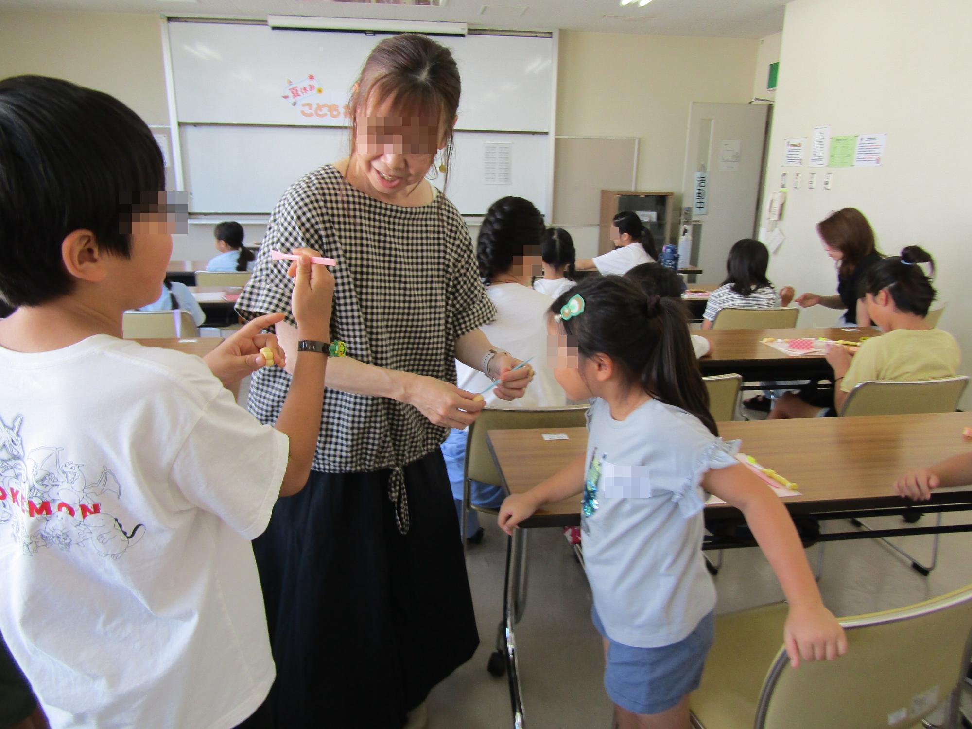 講師の先生に歩み寄り、自分がつくったねんどのパンを見てもらうようす