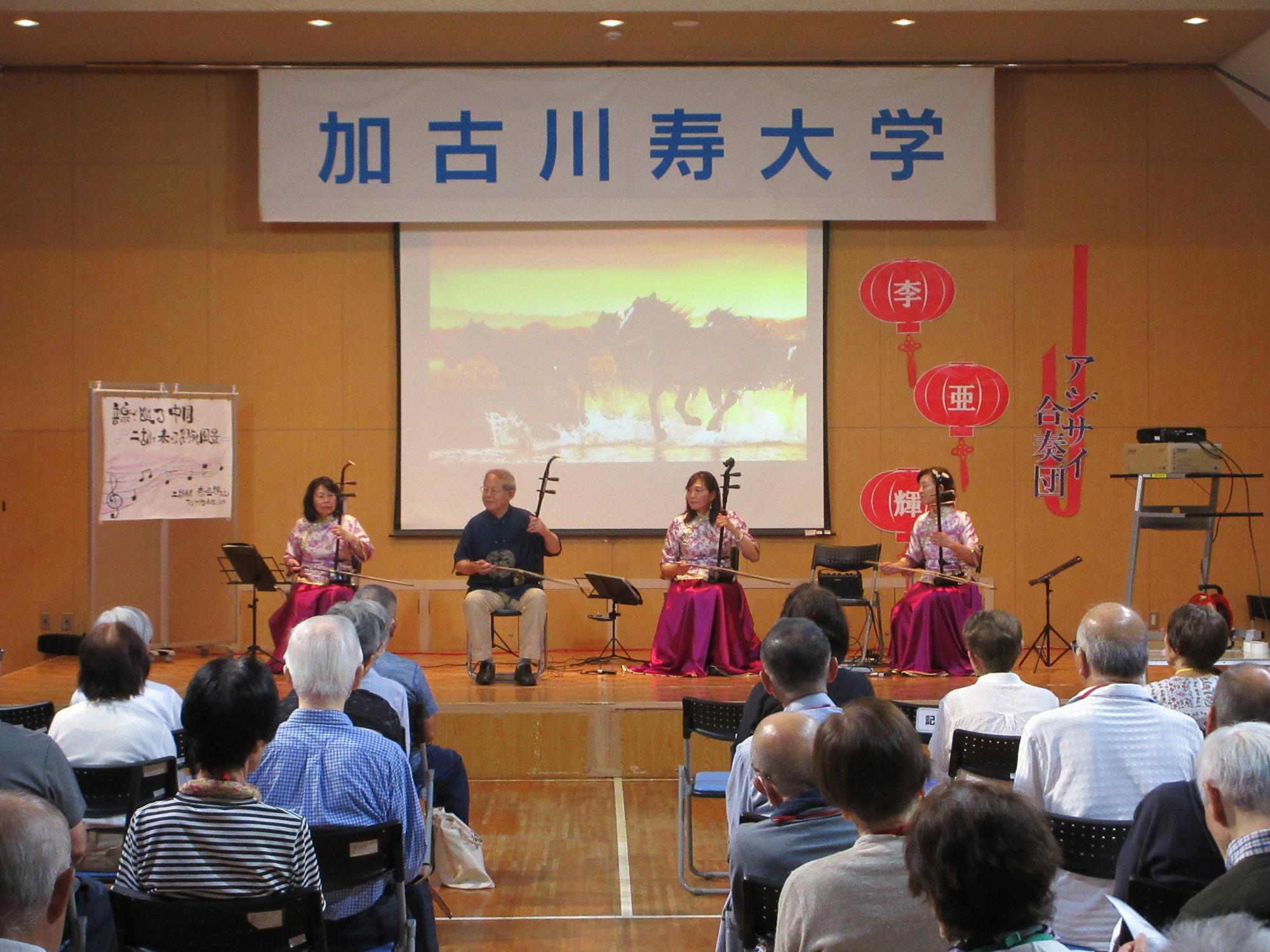 舞台で演奏する講師陣と、演奏に聞き入る学生たち