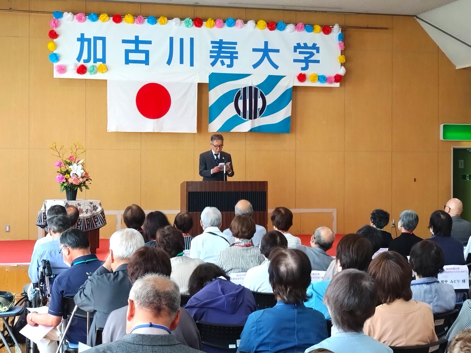 学生の代表が、檀上でお祝いの言葉を述べているところ