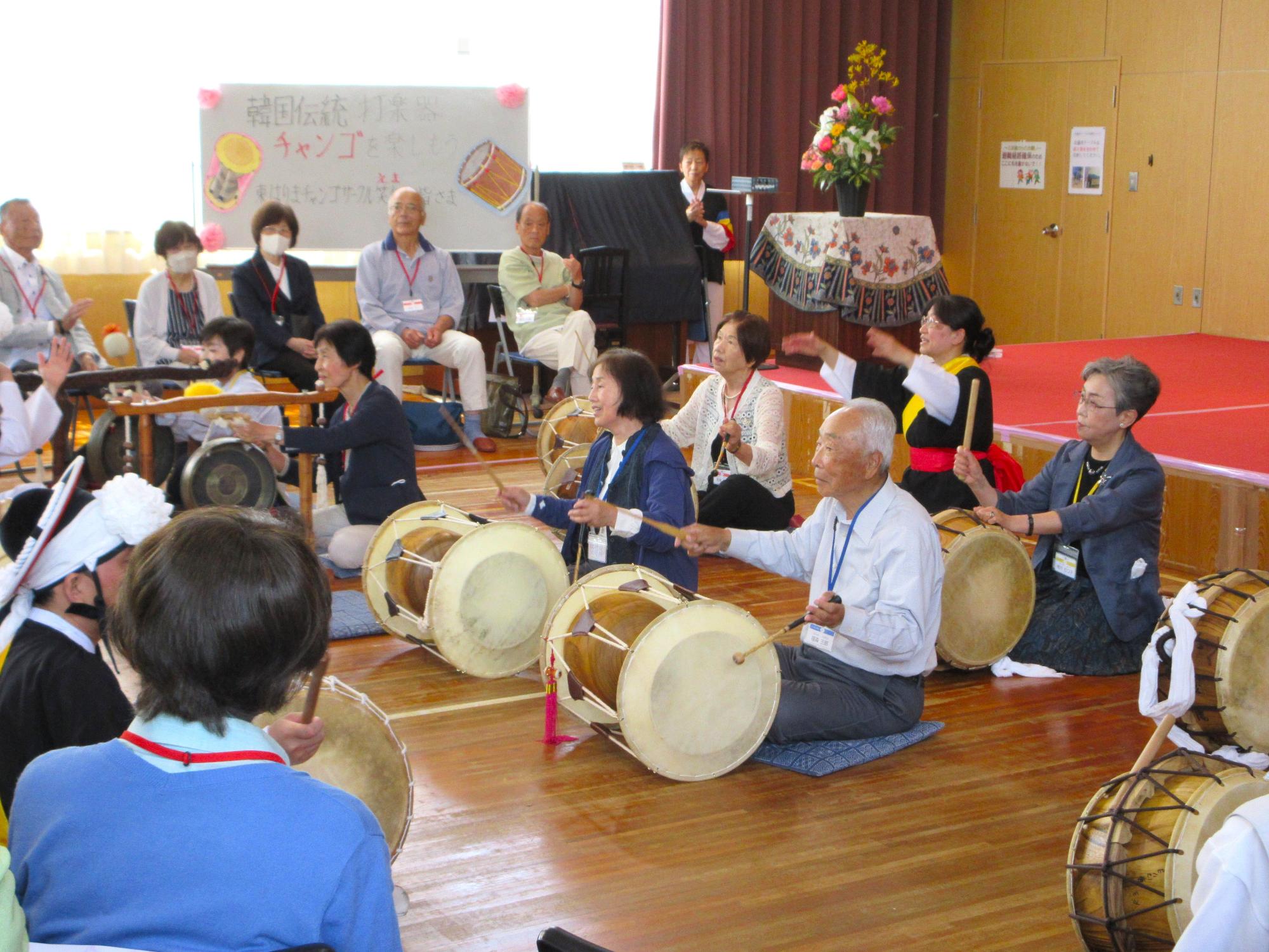 学生のうち希望者が、韓国の伝統打楽器を演奏体験している様子