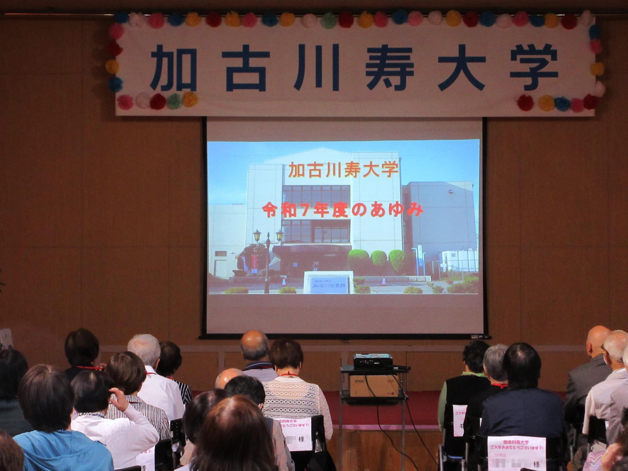 昨年度の寿大学の活動報告を、プロジェクターに映し出しているところ