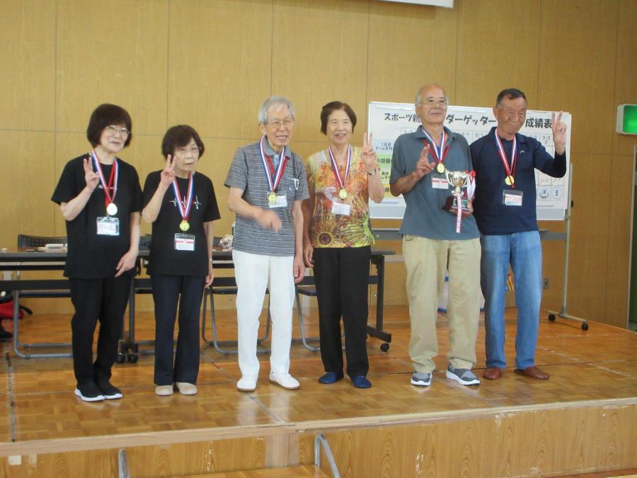 団体優勝した1年生チーム。メダルを提げ、トロフィー片手に写真撮影。