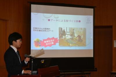 スクリーンを使い加古川アートセンター構想の発表をする男性の写真