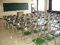 講義室の写真。教卓の前にパイプ椅子が整然と配置されている。