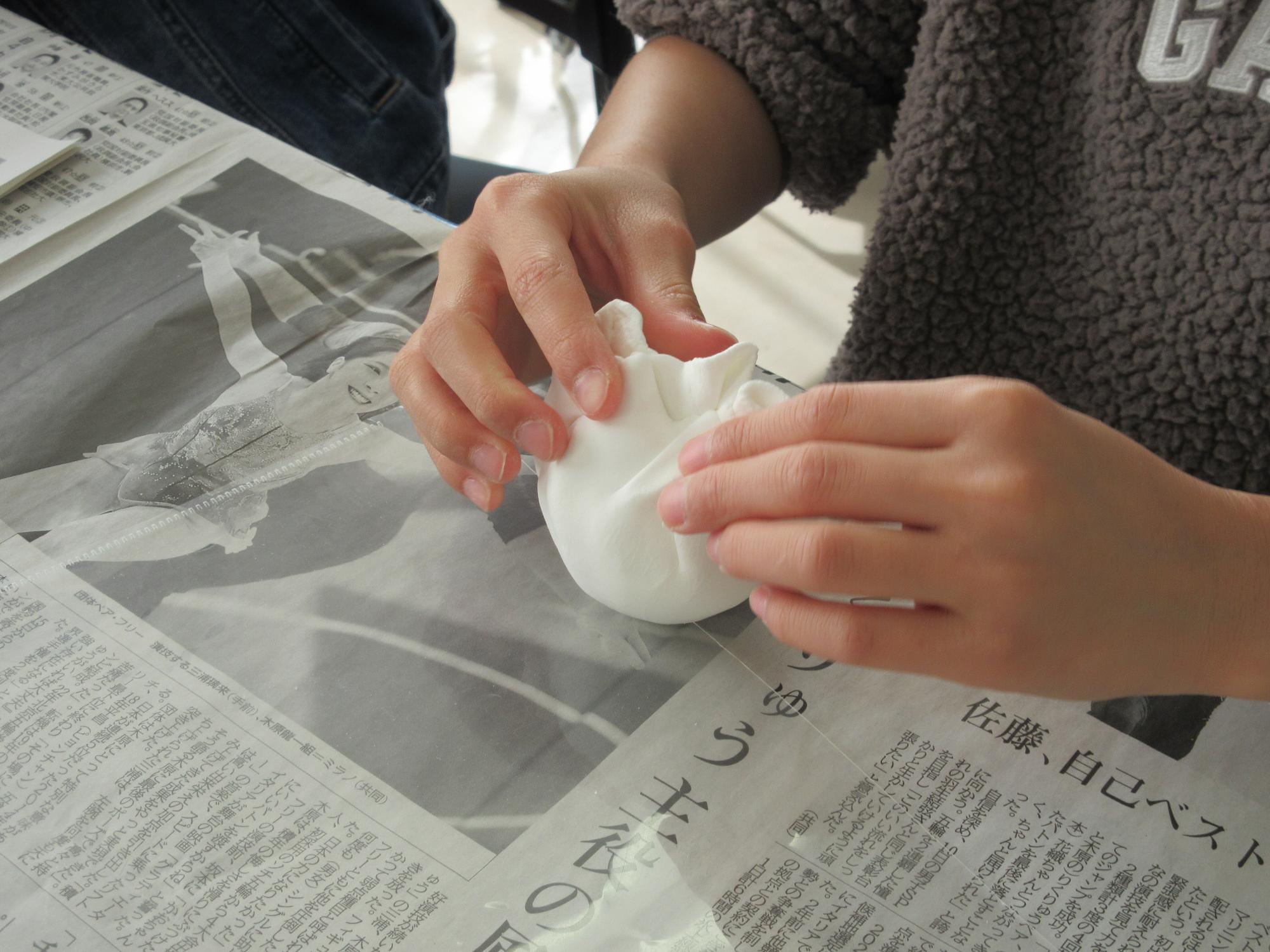 紙粘土をガチャガチャカプセルにつける様子