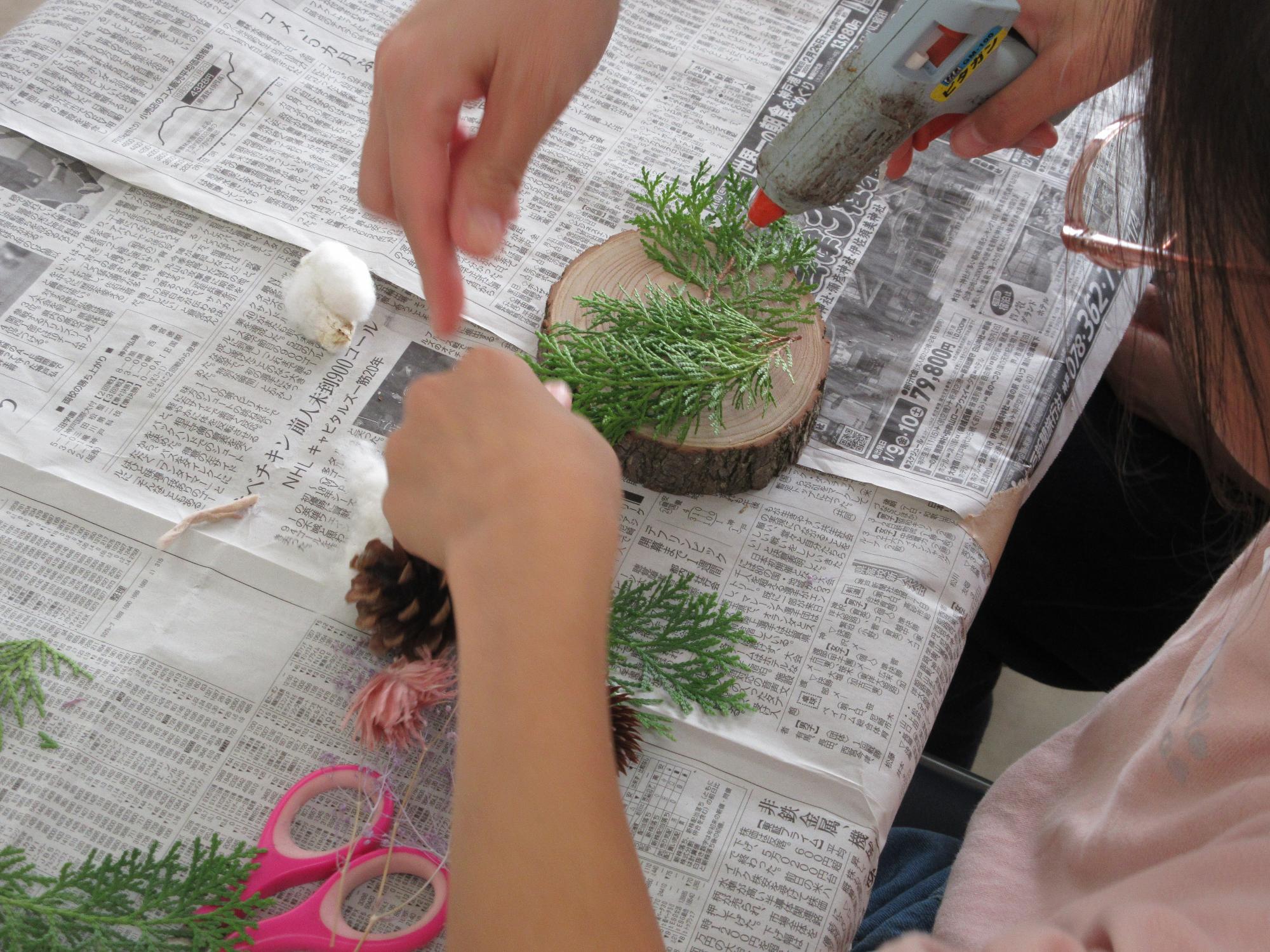 切り株に葉っぱをつける作業の様子