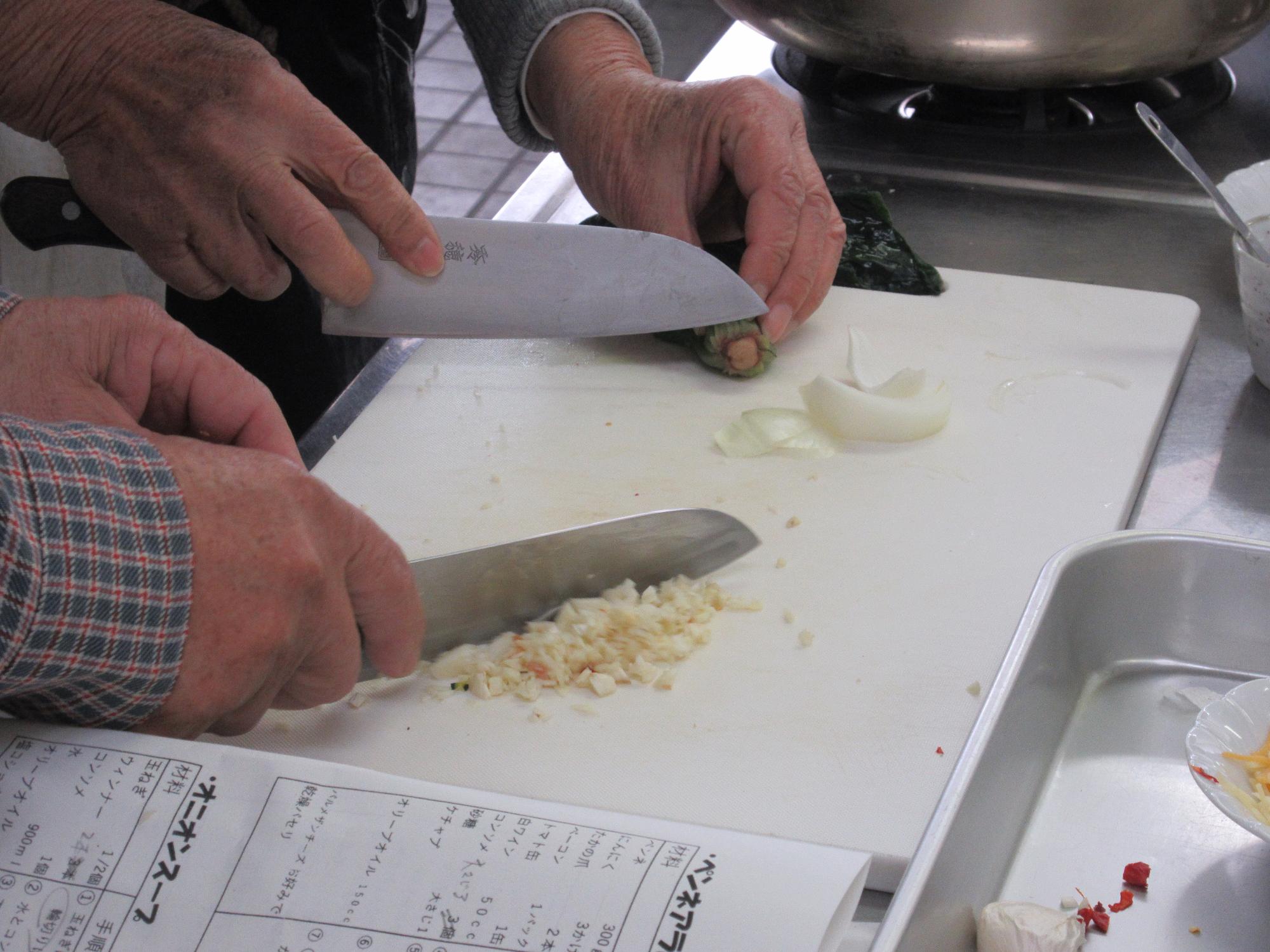 包丁でニンニクをみじん切りにするようす