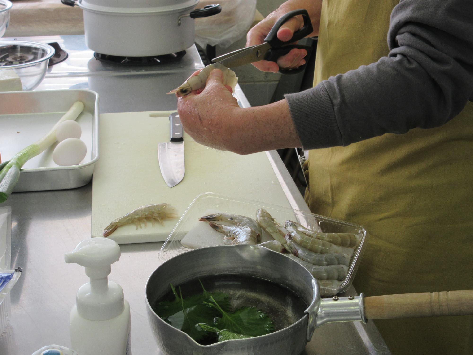 エビの背ワタをハサミでとるようす