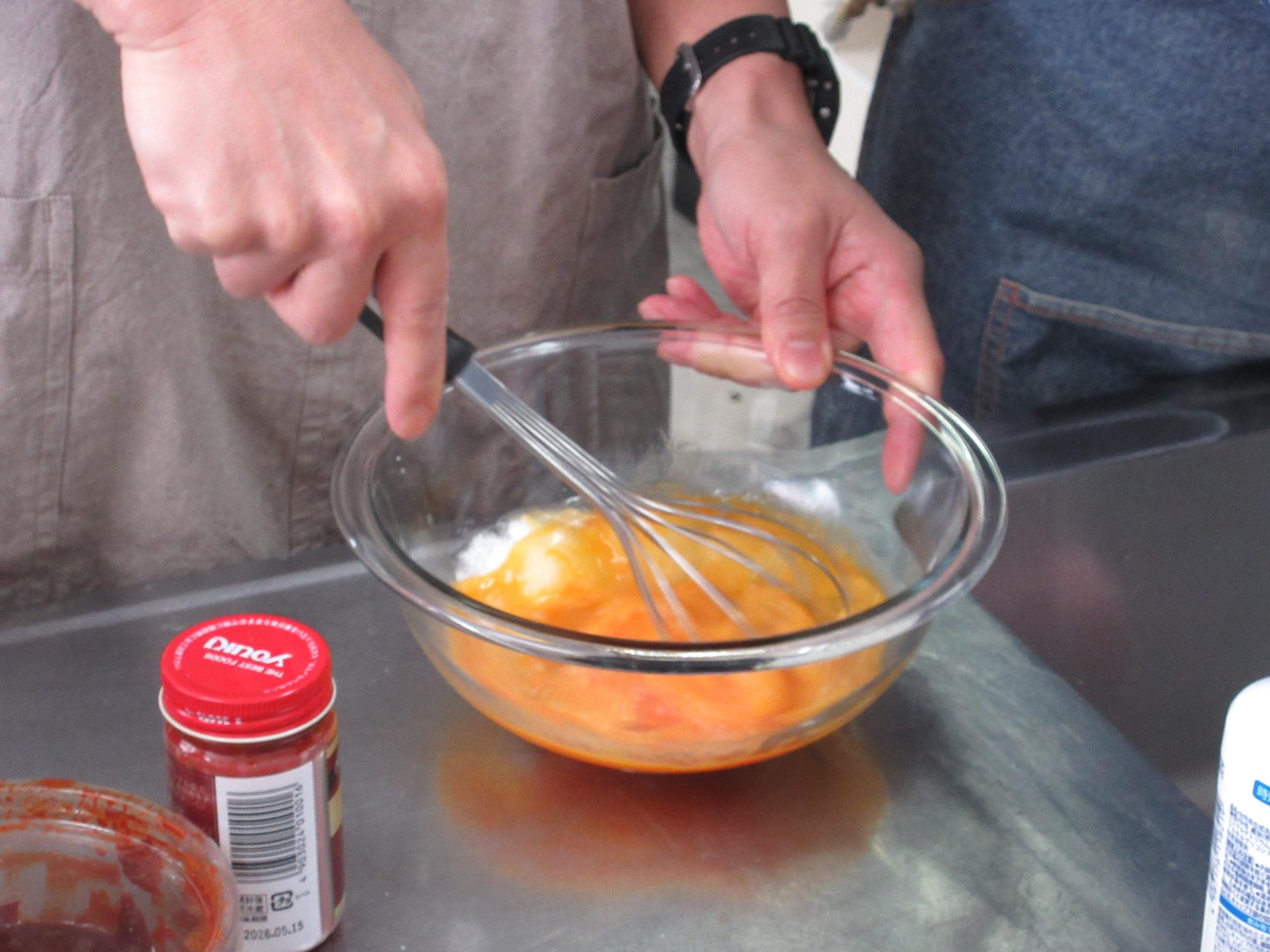 卵と砂糖を混ぜ合わせるようす