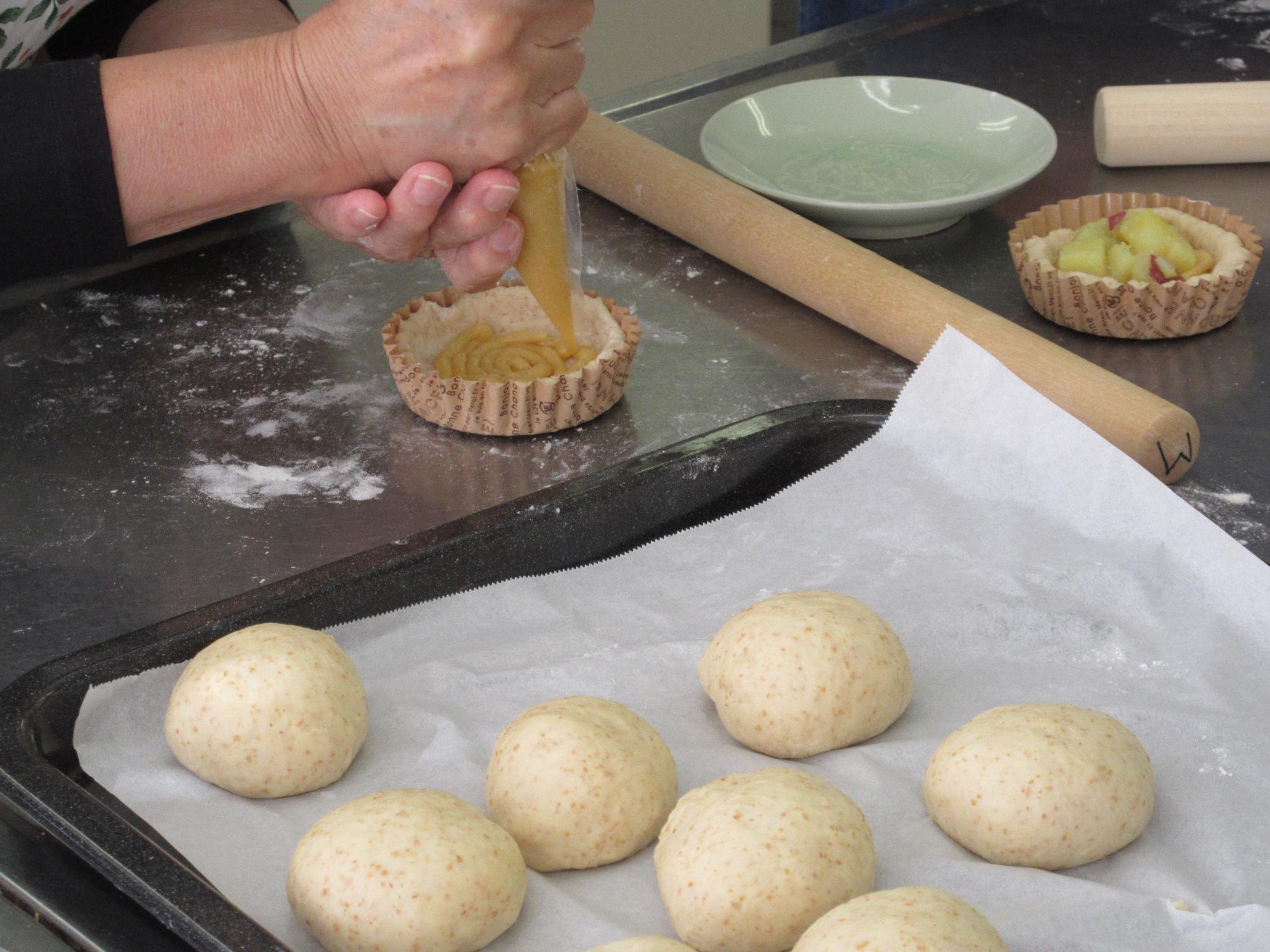 パン生地にクリームを絞る様子