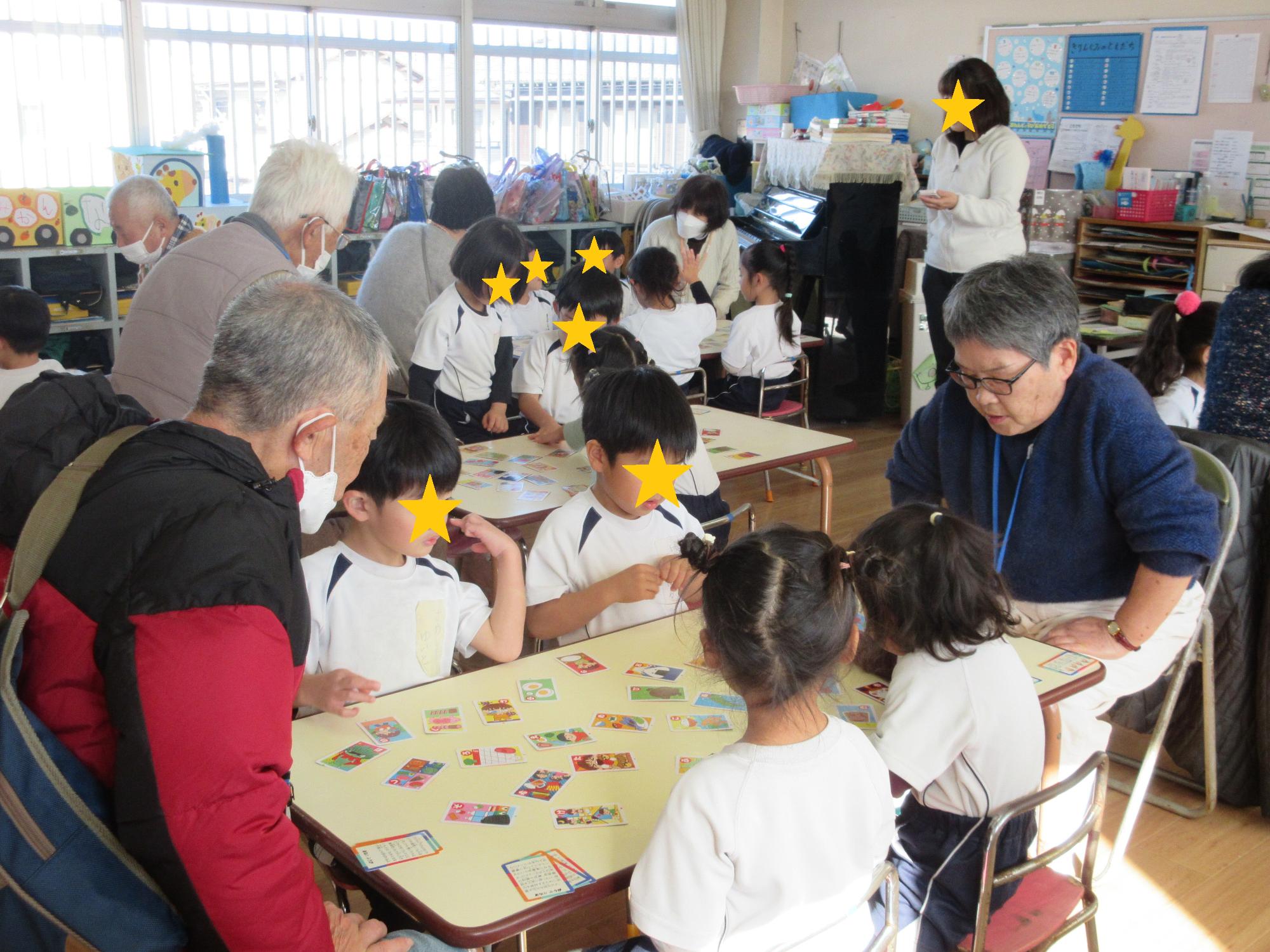カルタで学生さんと園児たちが勝負するようす