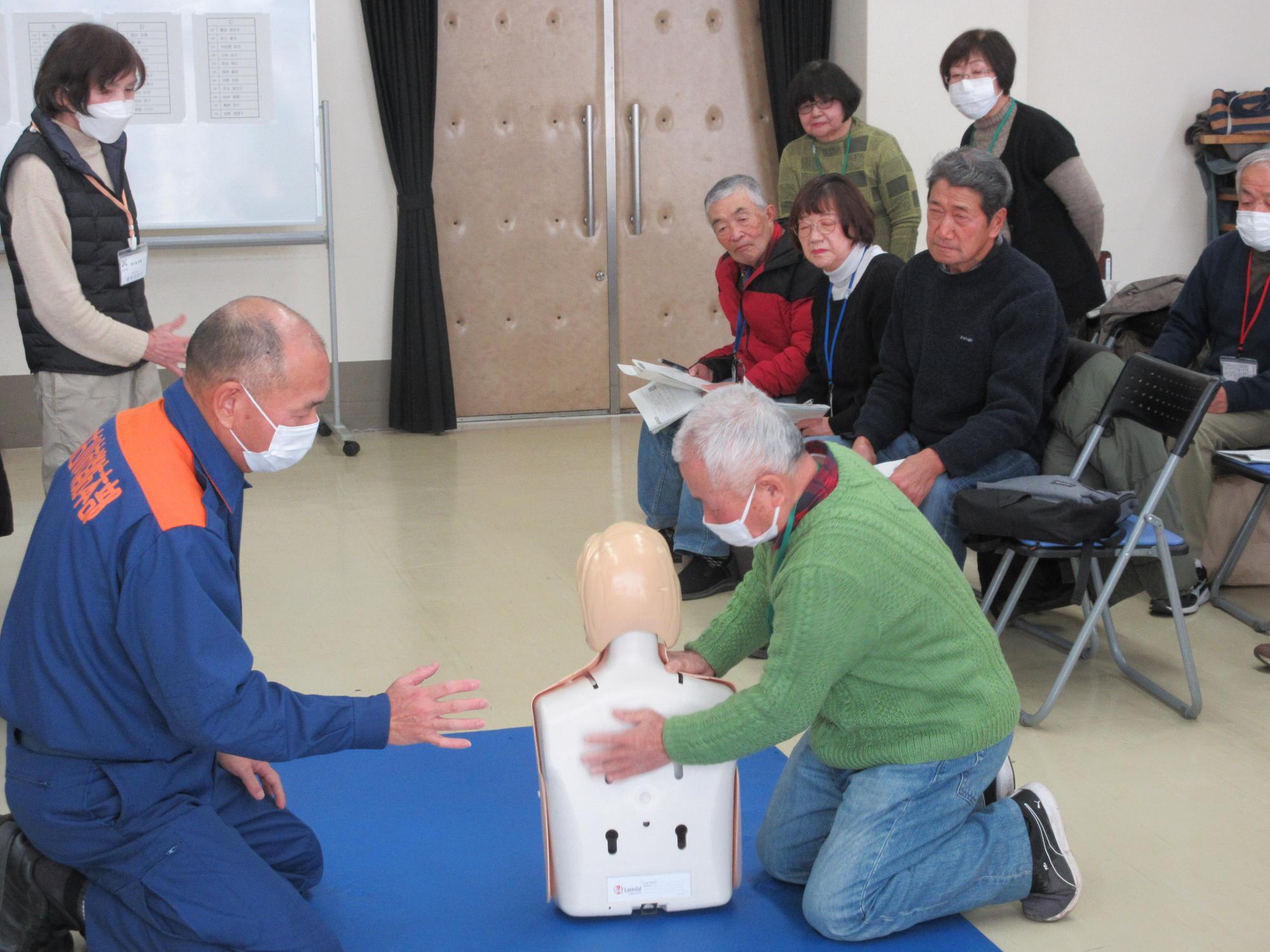 人形を使って、背部叩打法の実践を行う学生のようす