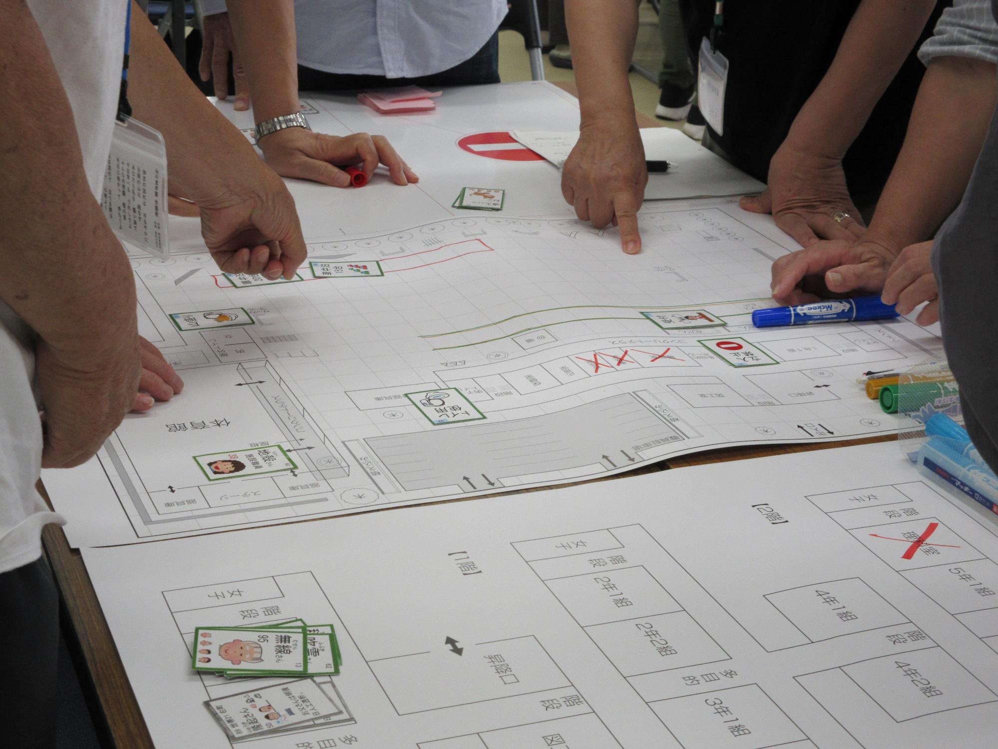 避難所の図面上で、トラブル対応を考えるようす