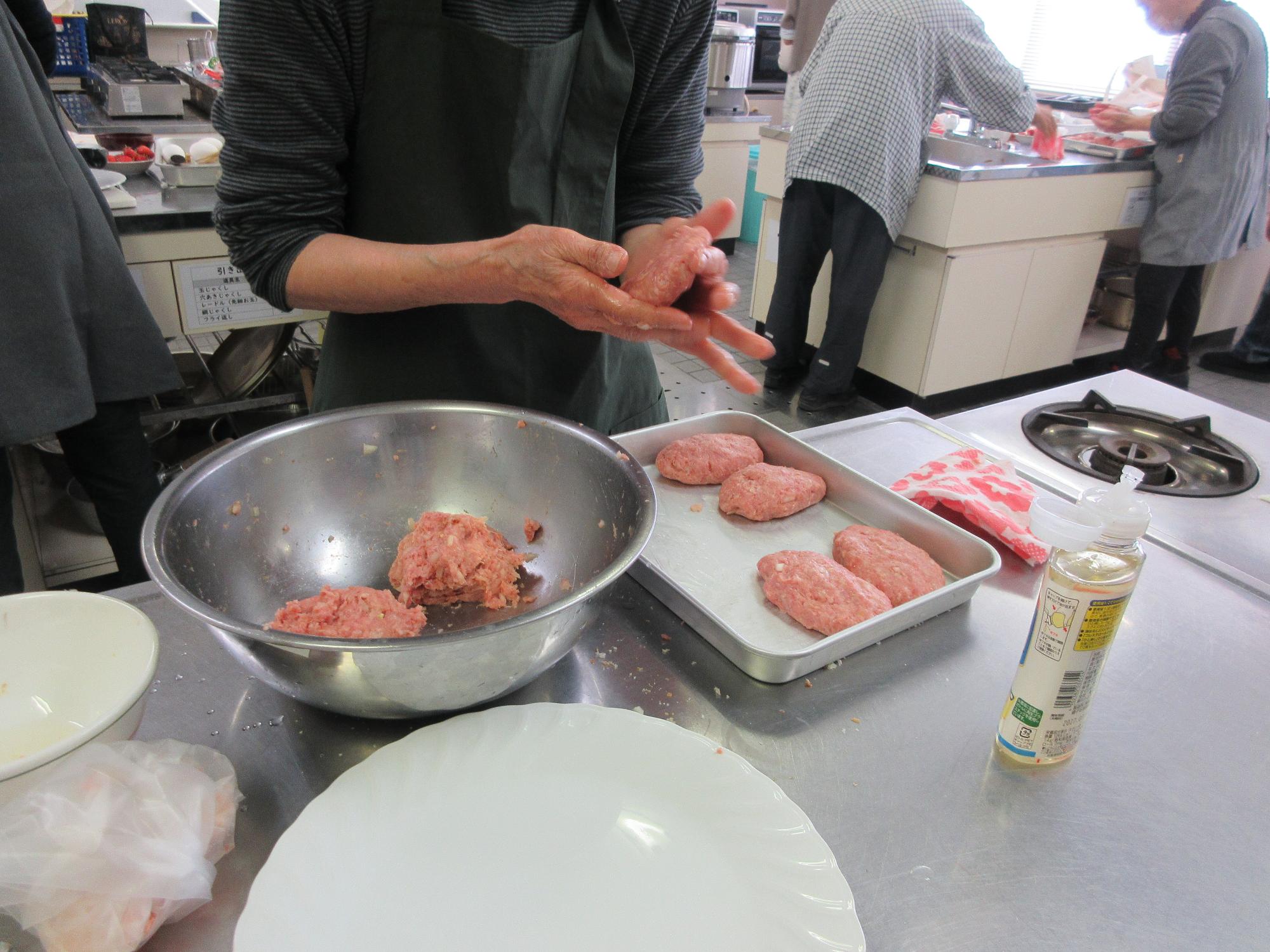 ハンバーグステーキのタネを丸めているようす