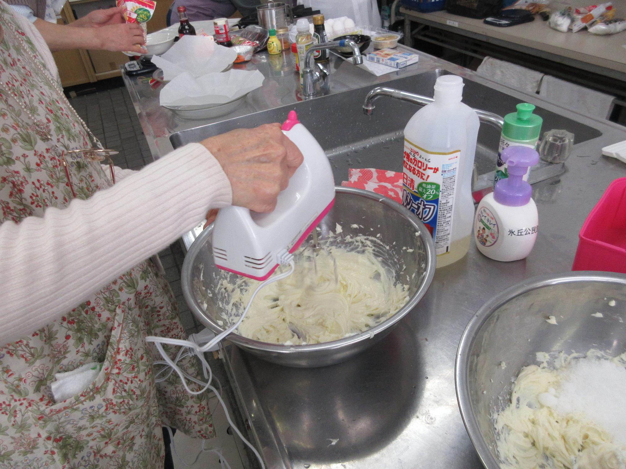 クリームチーズをハンドミキサーでクリーム状にするようす