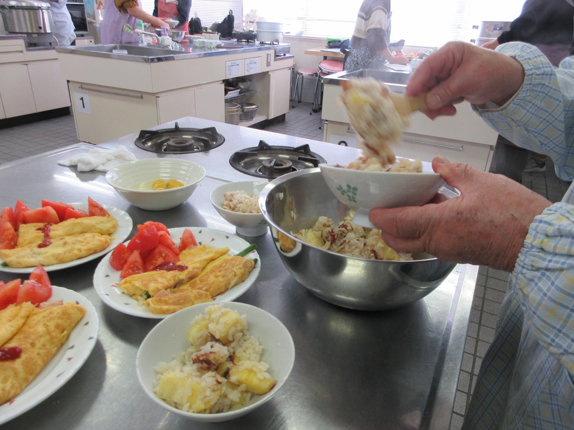 さつまいもと栗の炊き込みご飯をよそう様子