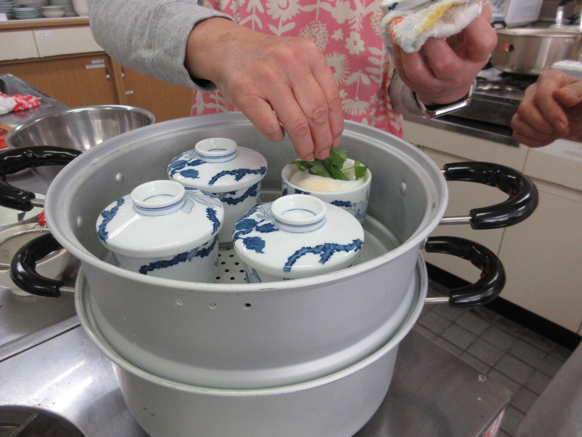 田毎蒸しに三つ葉を添える様子