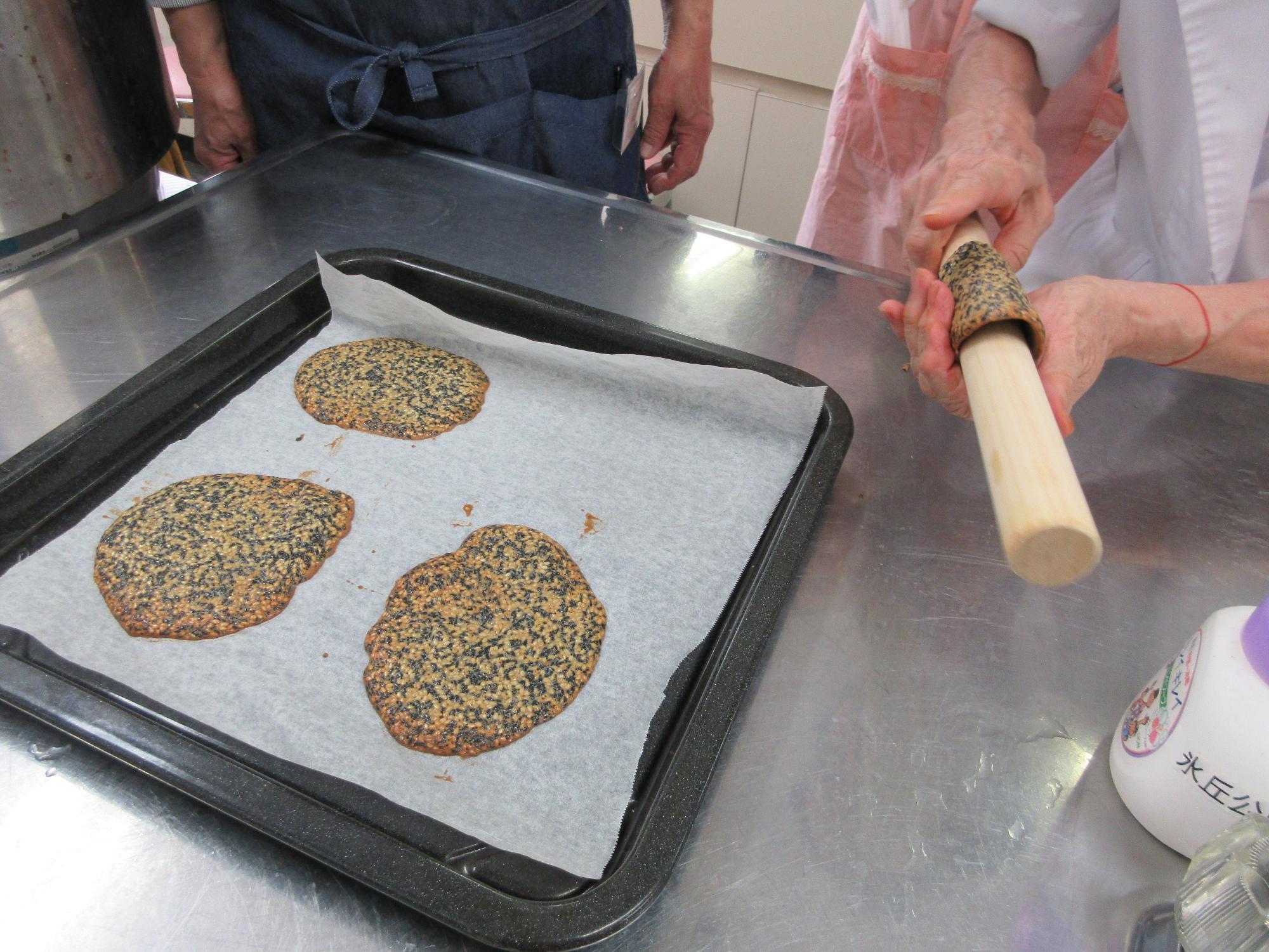 黒ゴマのチュイールを麺棒に巻き付けて丸みをつける様子