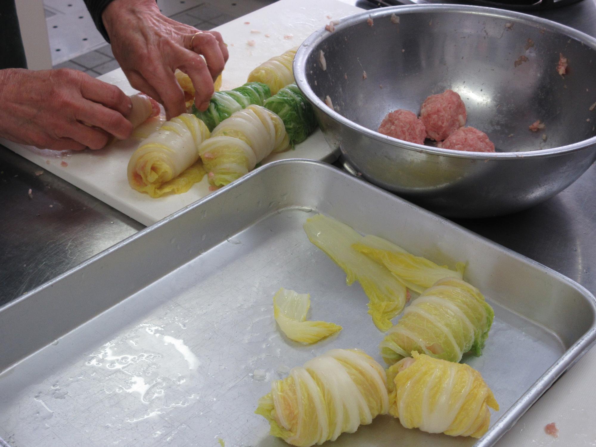 白菜で肉だねを巻くようす