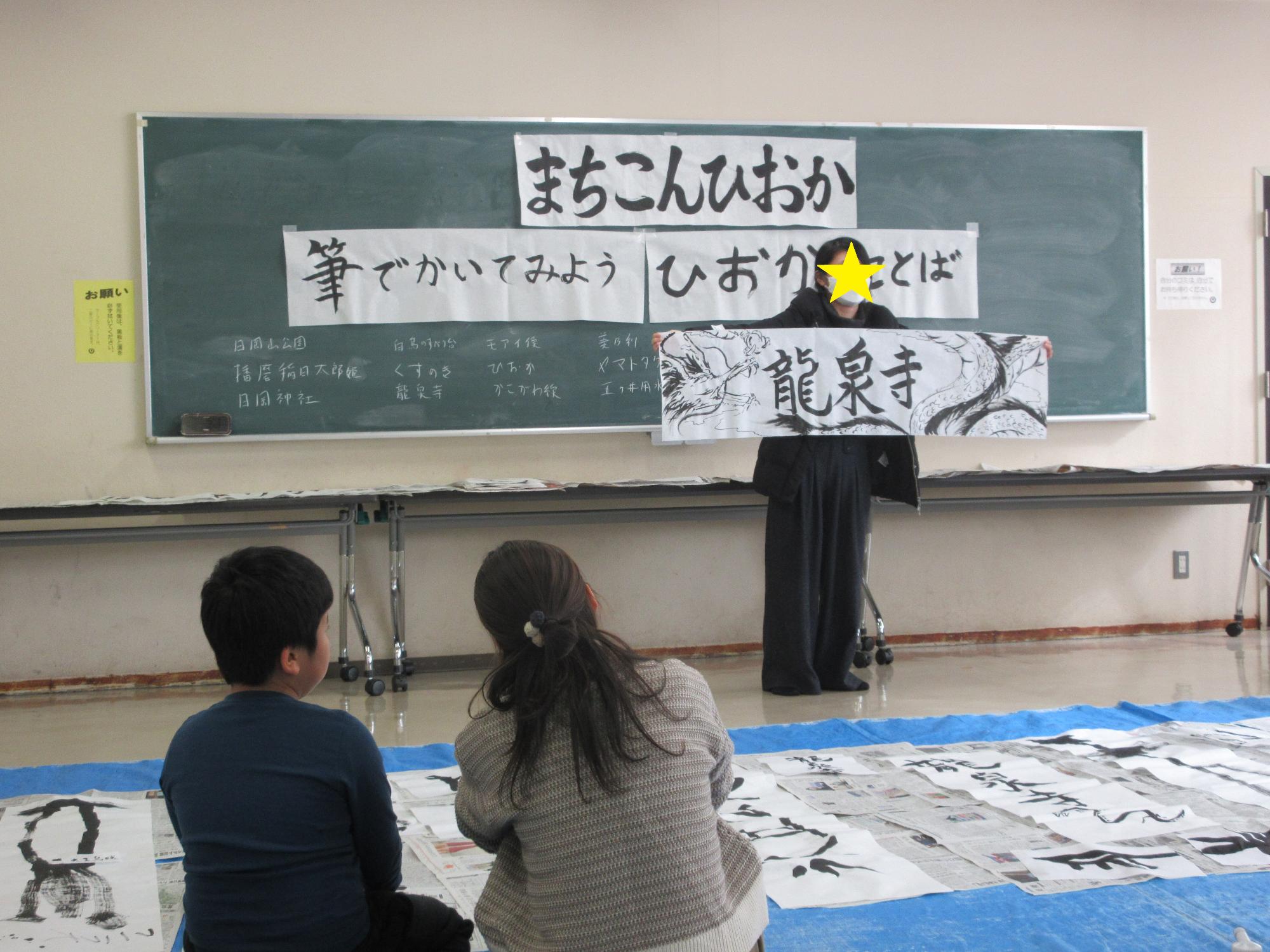 書いた作品を参加者に見せるようす