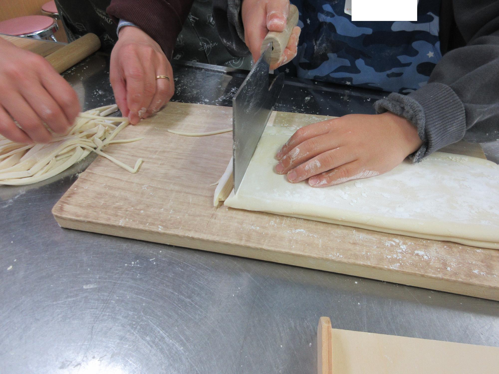 手打ちうどんを切る作業