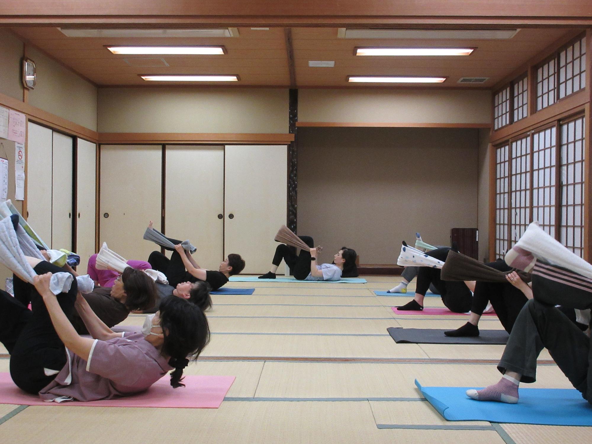 仰向けで寝ころび、タオルに足をかけ、上半身を起こす動き