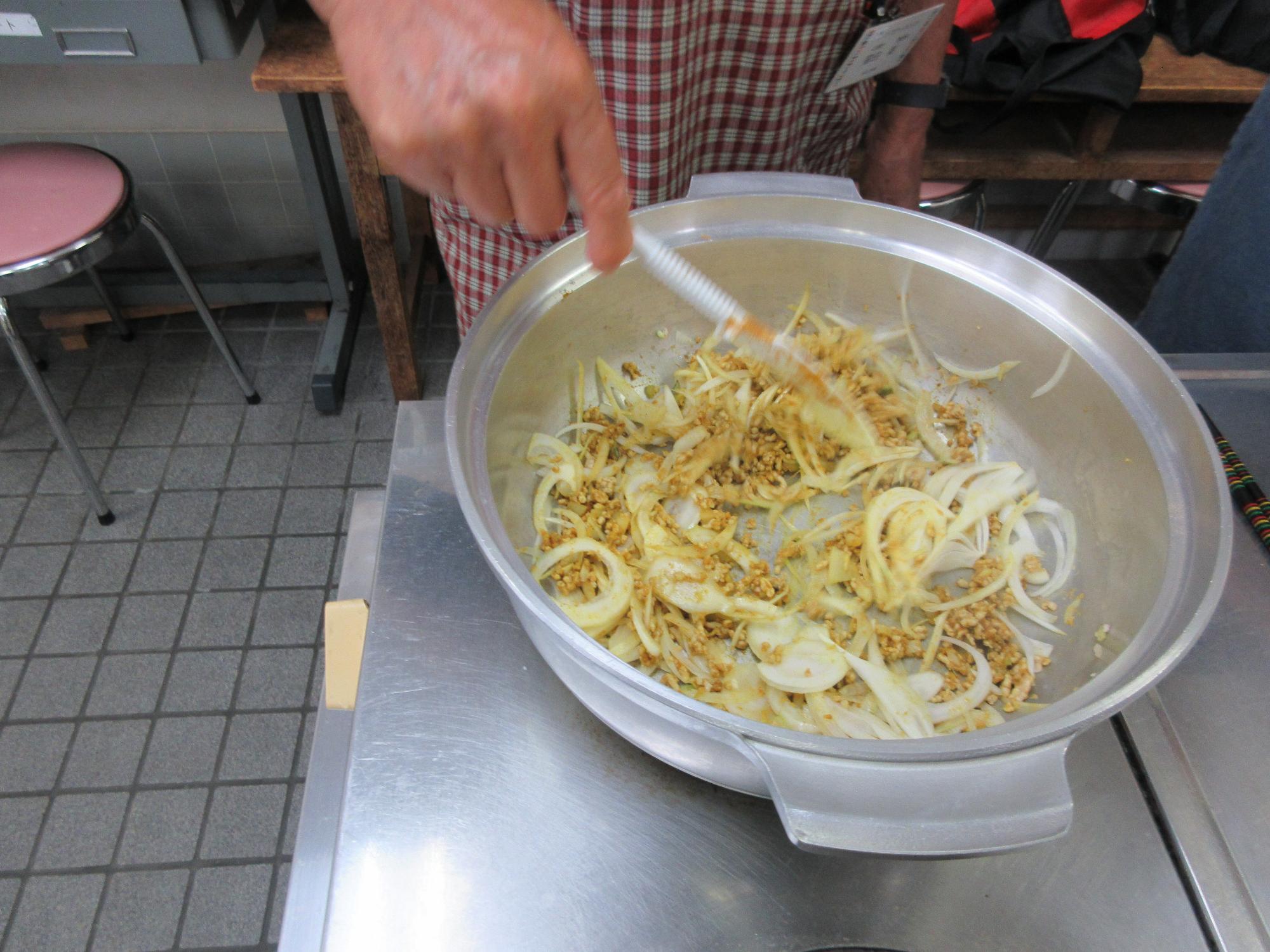 玉ねぎとひき肉を炒める様子