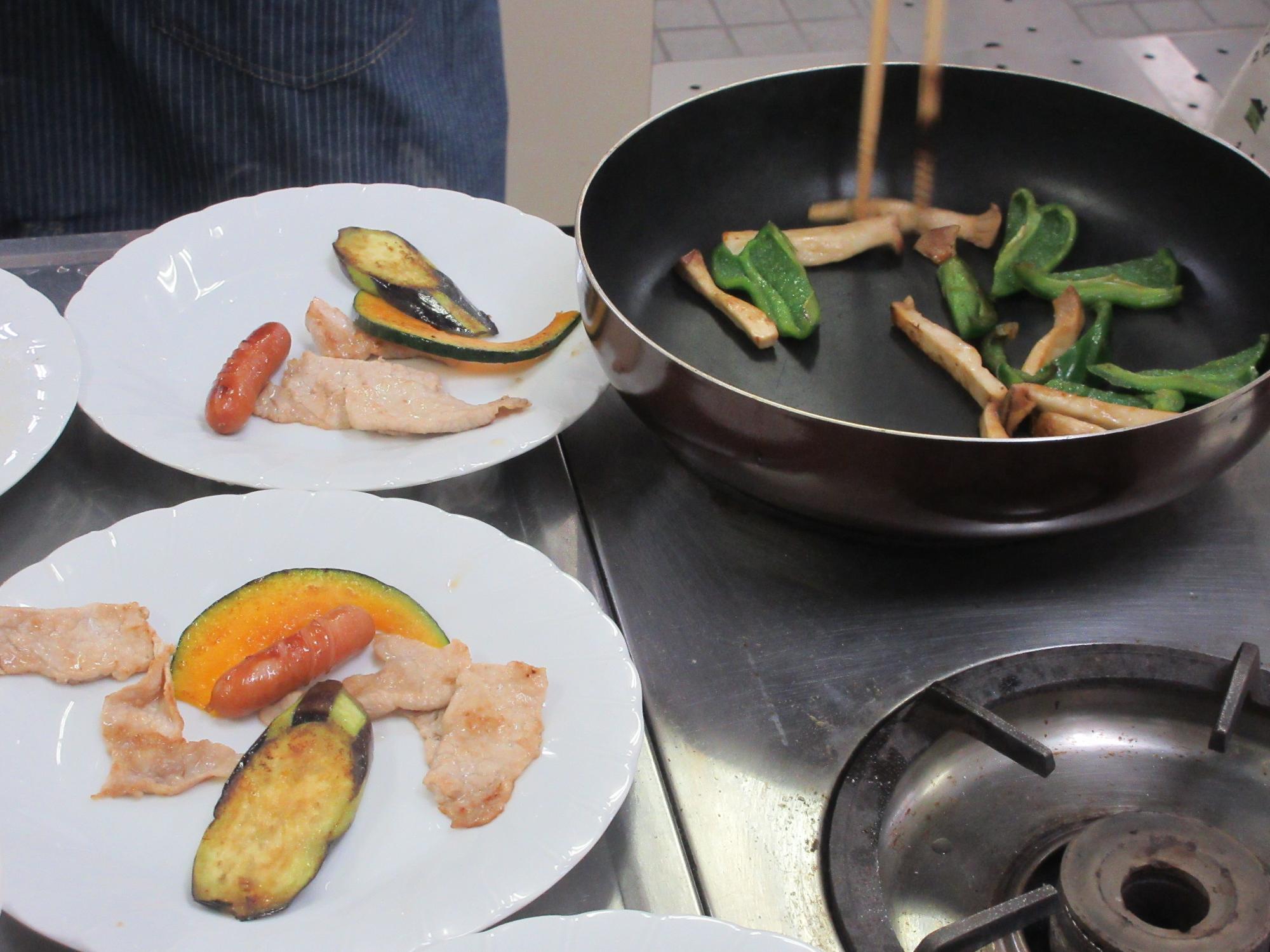 野菜をフライパンで炒める様子