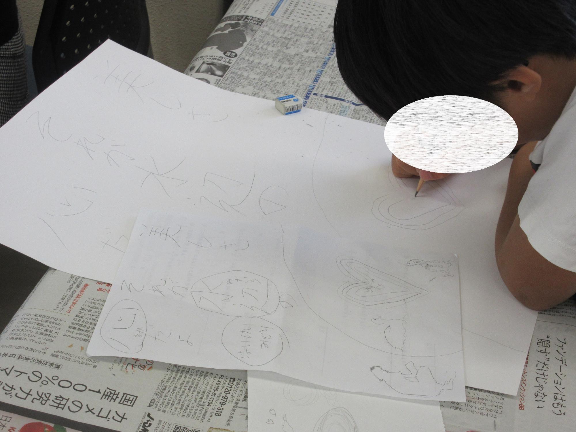 小学生がポスターの下書きをする様子