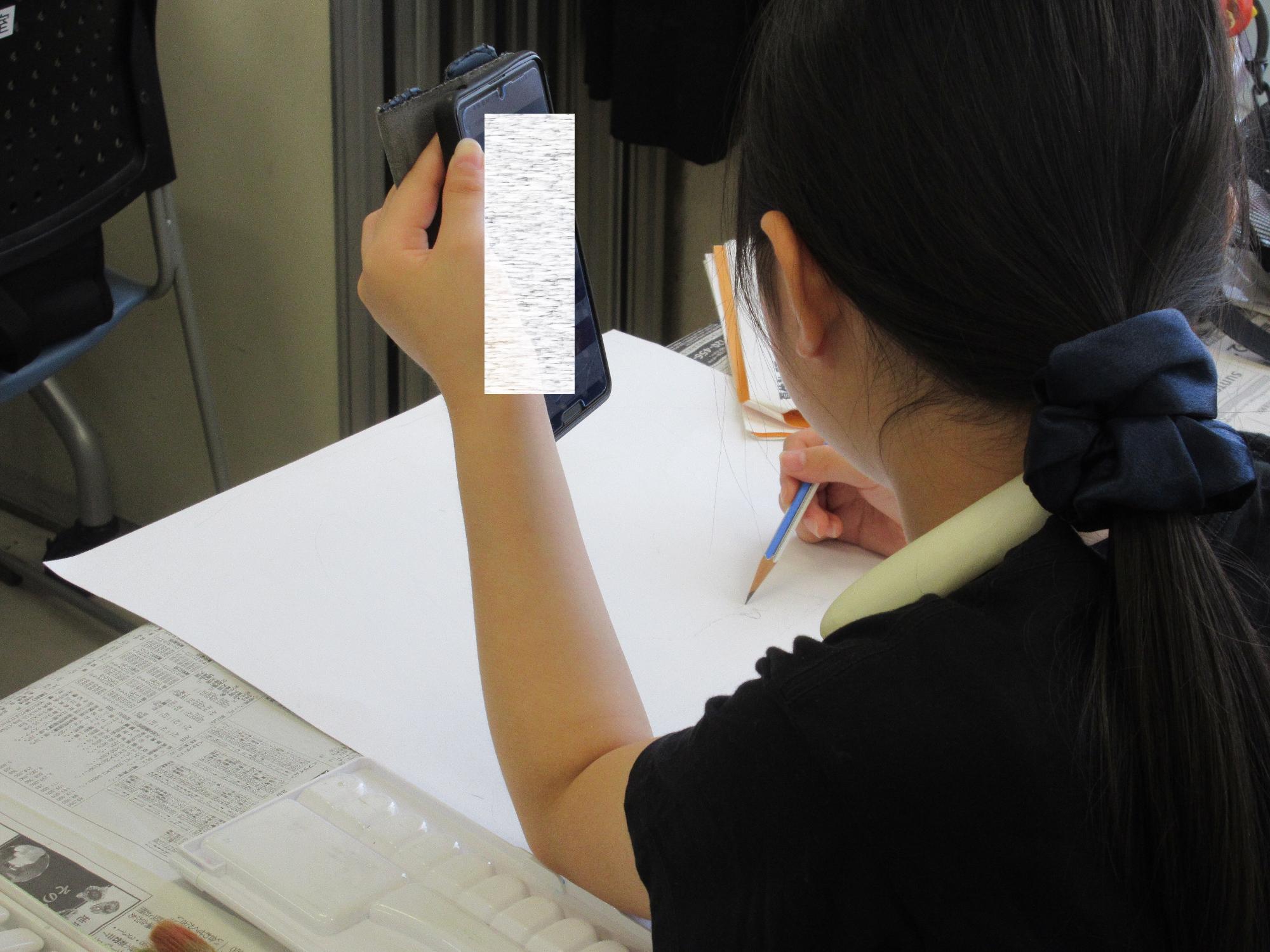 小学生がポスターの下書きをする様子